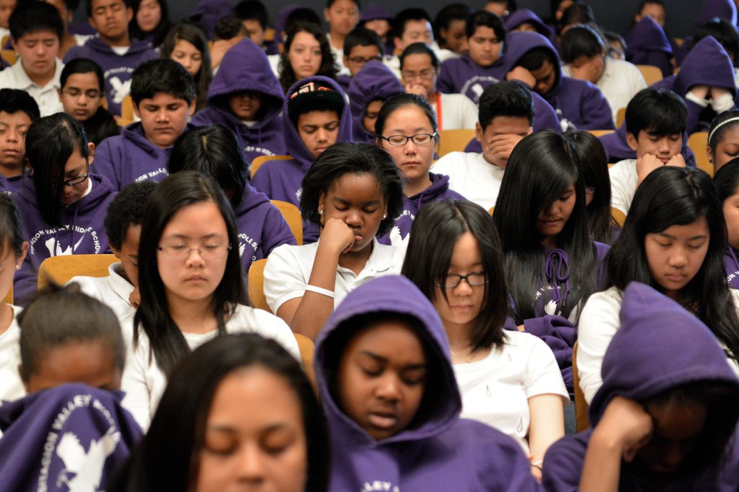 diverse group of young adults meditating 