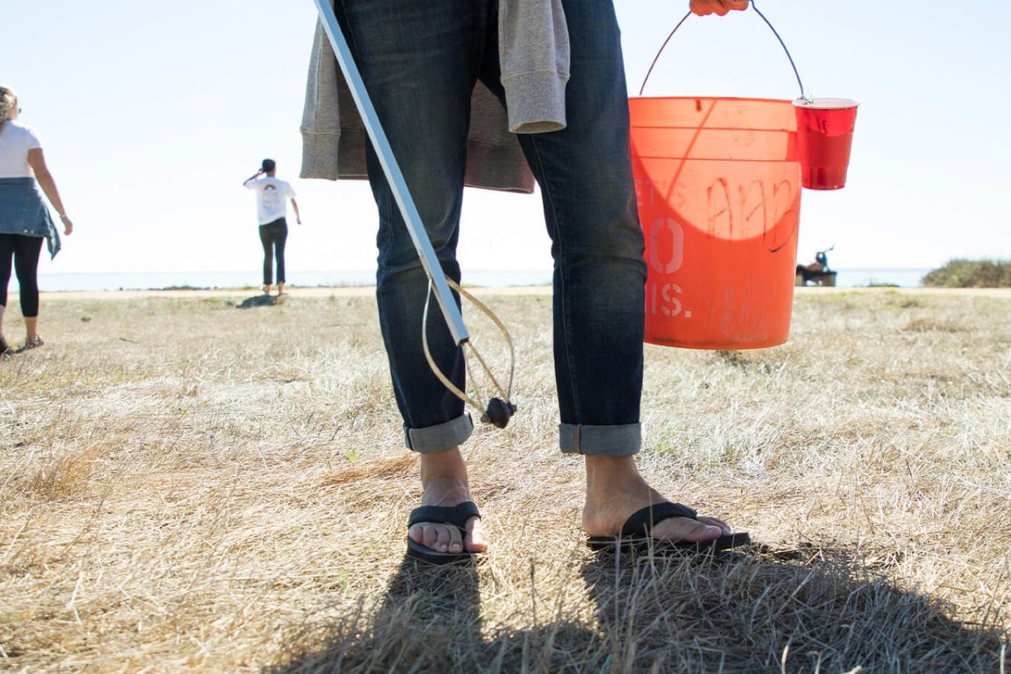 volunteer picking up trash near beach