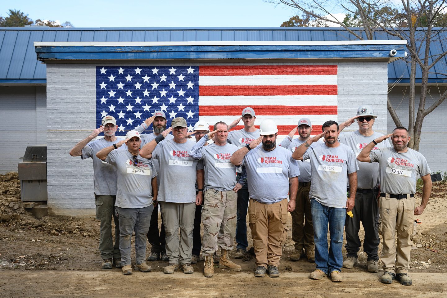 group of veterans saluting in front of an american flag