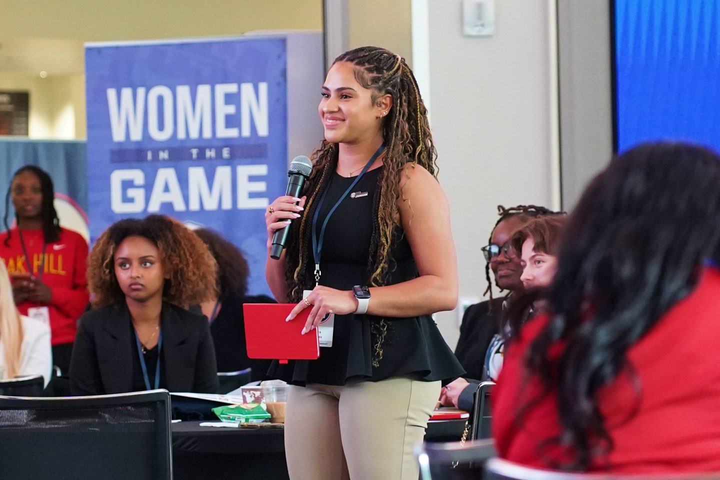 a woman holding a microphone in a conference