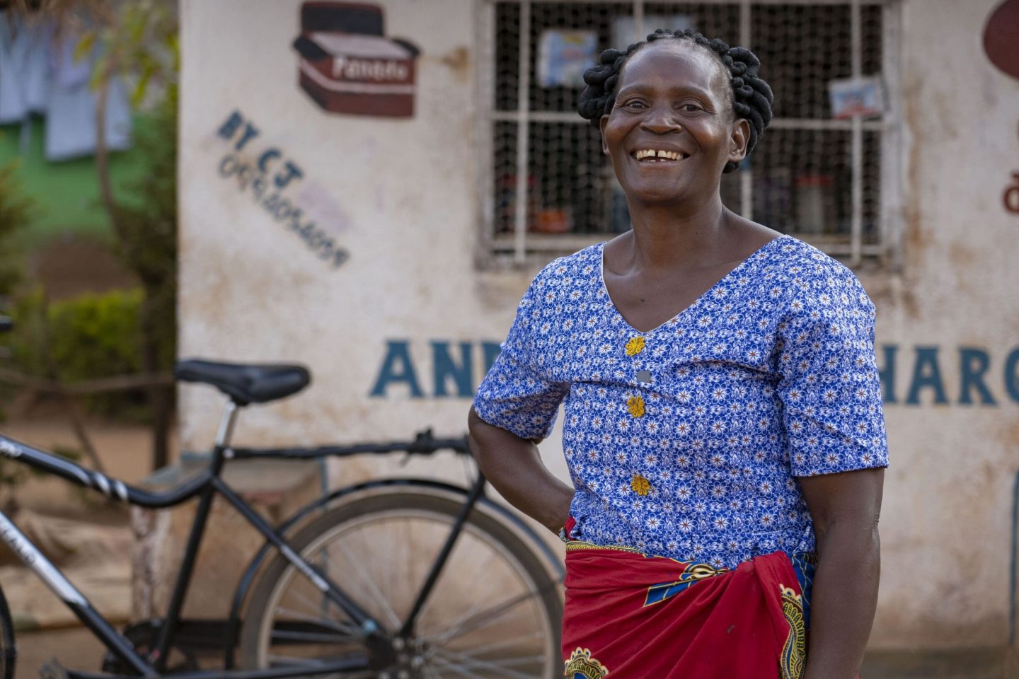 a happy rural woman with a bike in the background