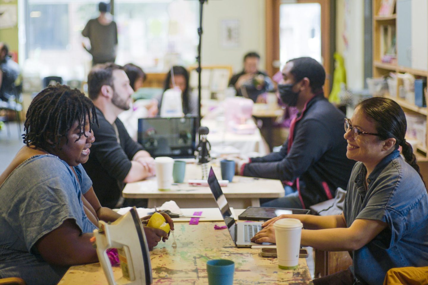 Men and women working on crafts and talking at a table