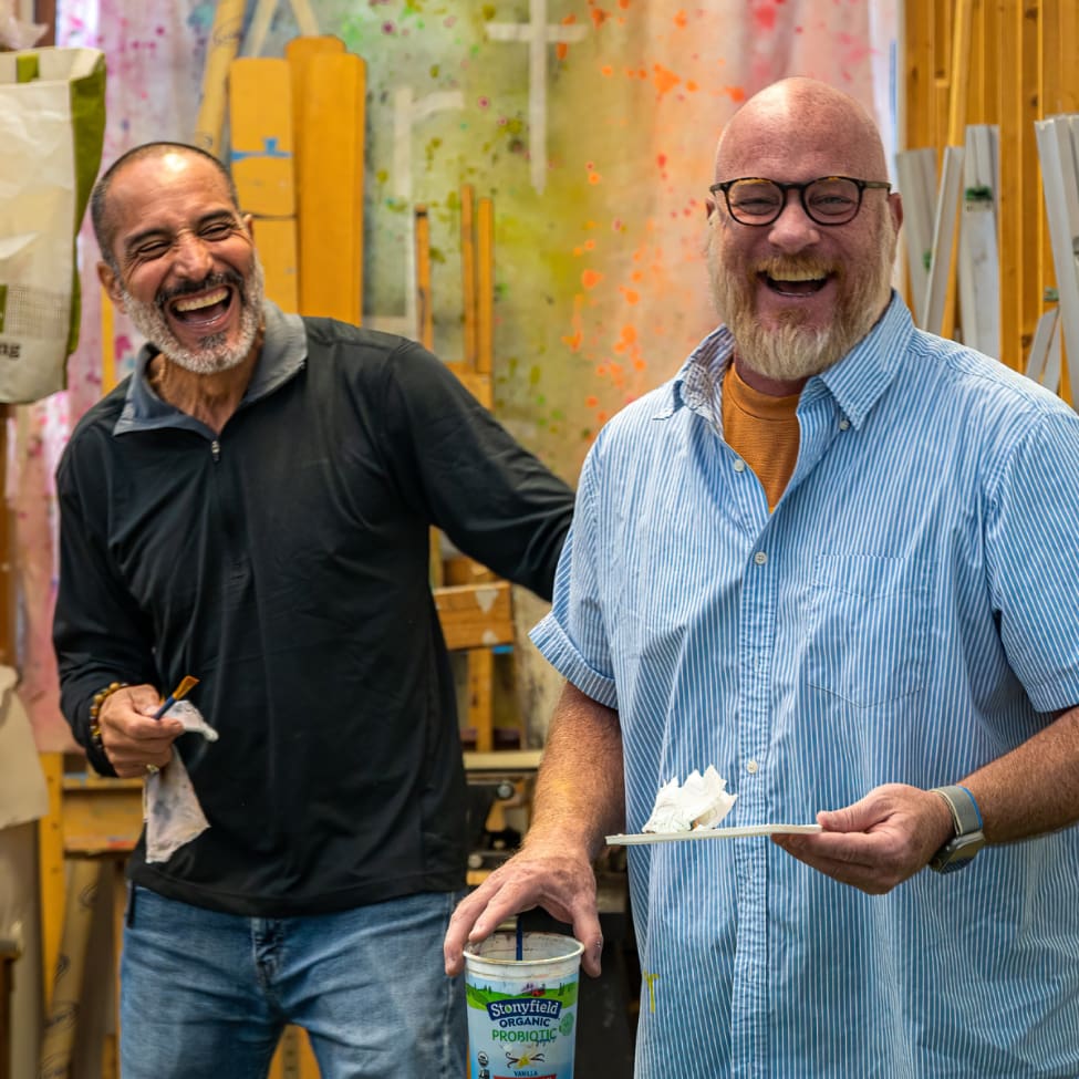 Two veterans smile during an art class Two veterans smile during an art class