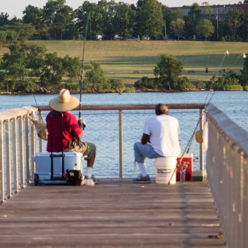 Two men fishing from a dock Two men fishing from a dock